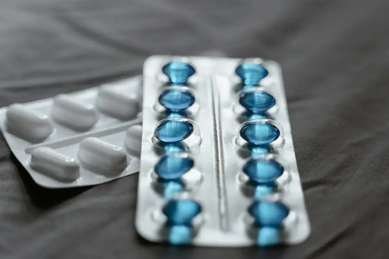 Dwa blistry leków: jeden z białymi kapsułkami, drugi z niebieskimi, które mogą być pregabalin accord.