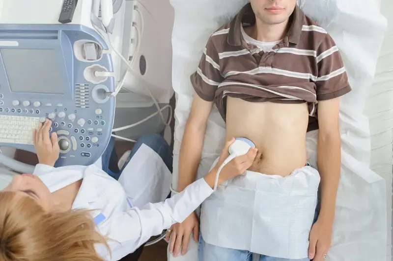 Lekarz wykonuje USG jamy brzusznej, by przeprowadzić test na zapalenie wyrostka robaczkowego.